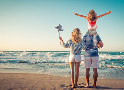 family on a beach: money-saving tips for holiday